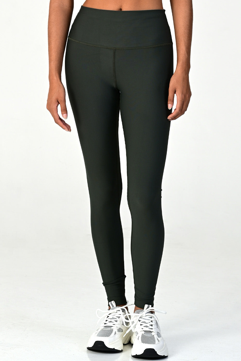 Zoomed front view of a woman wearing the Soho dark olive active legging on a white background