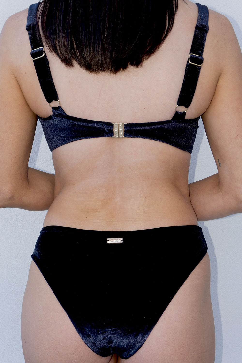 Close-up back view of a woman wearing the Laguna Bikini Black Velvet Set with regular coverage bottom