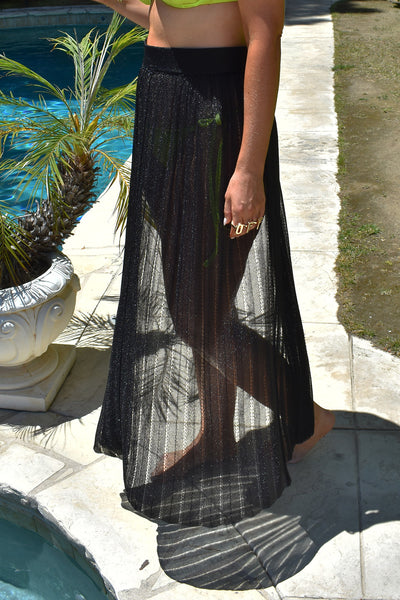 Zoomed Side view of a woman wearing the Black Metallic Skirt on Poolside background