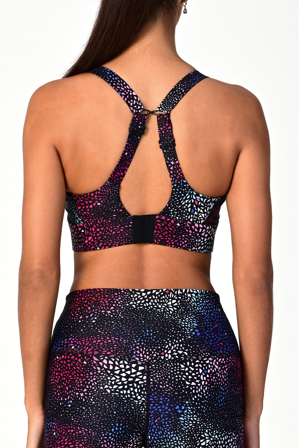 Back view of a woman wearing the Soho galaxy active bra top with shoulder straps fastened..