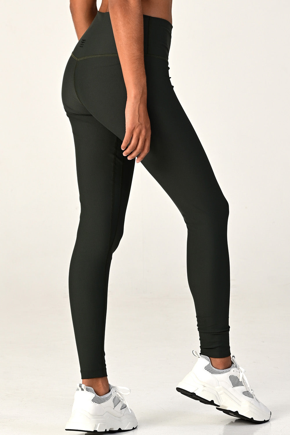 Side view of a woman posing wearing the soho olive active legging