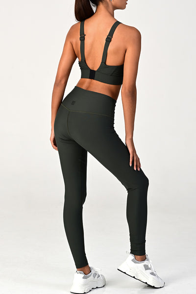 Back view of a woman posing wearing the soho olive active set.
