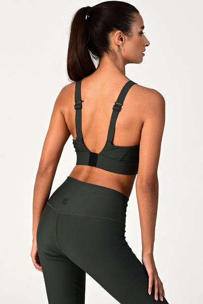 Back view of a woman wearing the Soho dark olive active bra on a white background