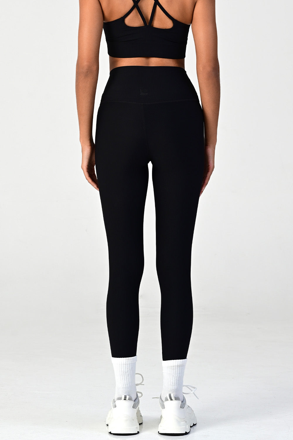 Woman wearing the melrose black ribbed leggings close up back view