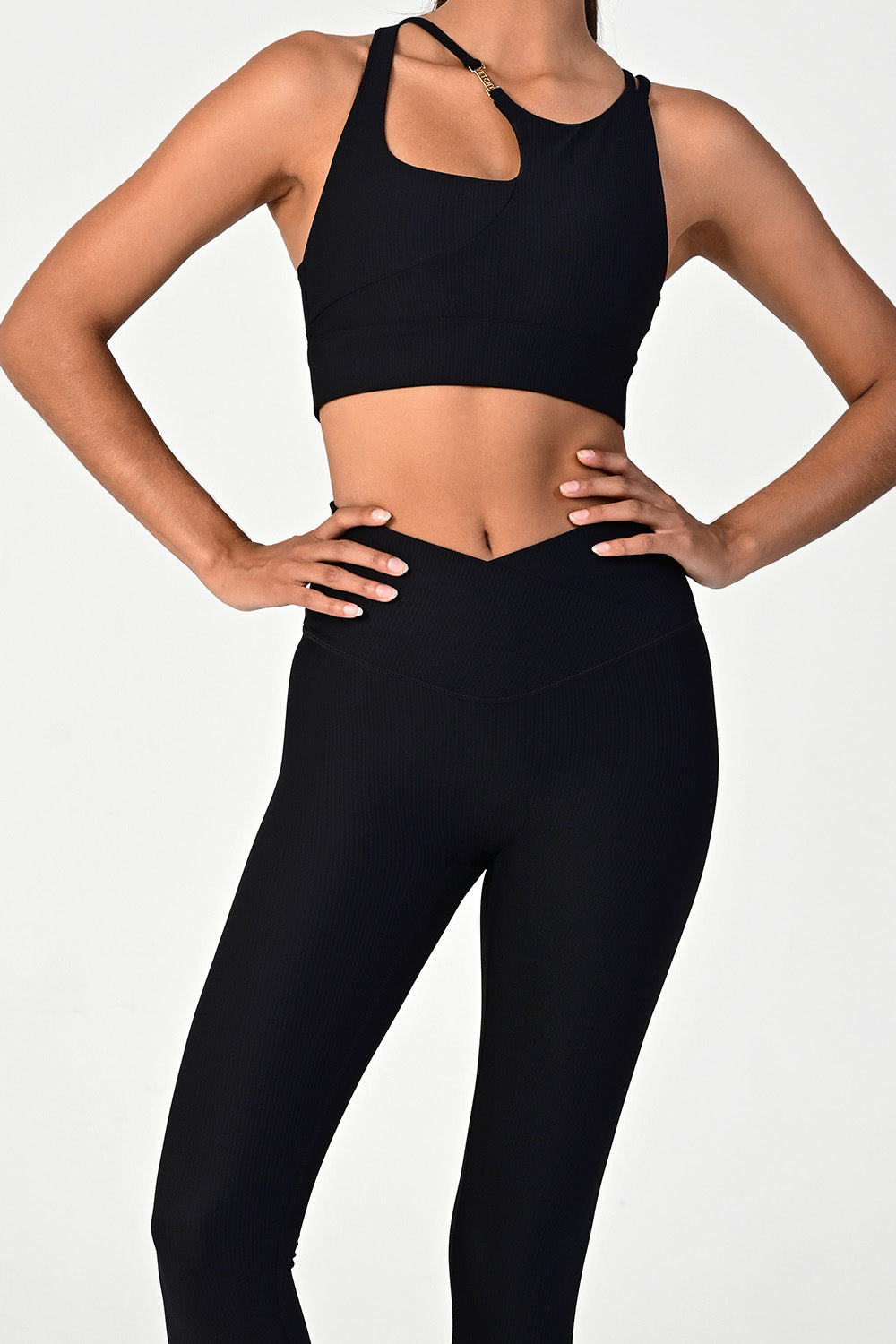 Woman posing and wearing the melrose black ribbed leggings and bra top close up front view