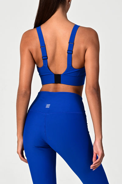 Back view of a woman posing wearing the Soho cobalt active bra top.